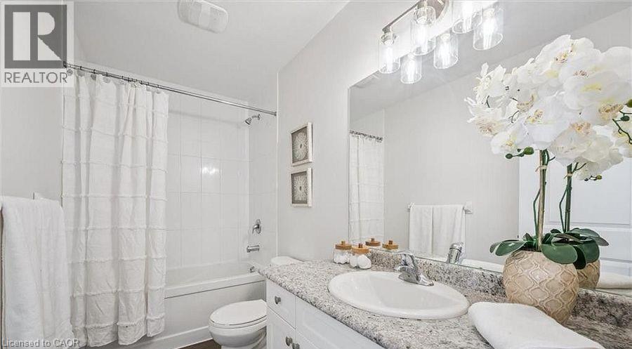 Full bath featuring vanity and shower / bath combo with shower curtain - 24 Morrison Road Unit# D9, Kitchener, ON - Indoor Photo Showing Bathroom