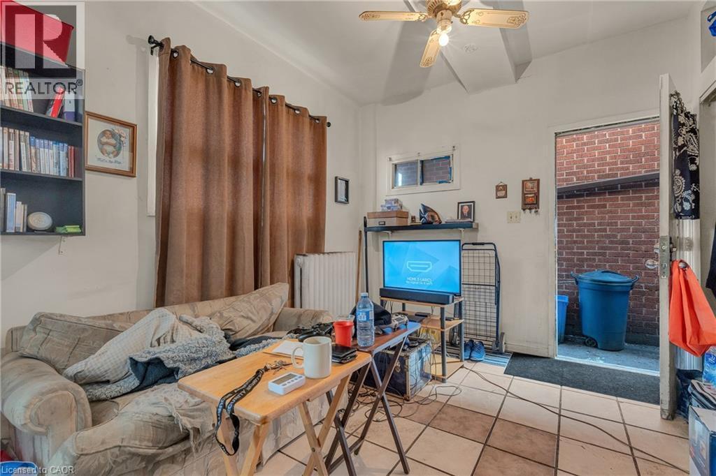 Tiled living area featuring radiator heating unit, a ceiling fan, and vaulted ceiling - 70 Ottawa Street N, Hamilton, ON - Indoor