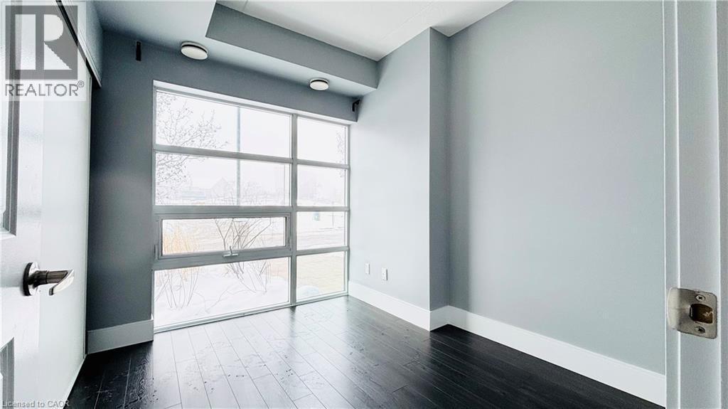 Unfurnished room with wood finished floors and baseboards - 155 St. Leger Unit# 107, Kitchener, ON - Indoor Photo Showing Other Room
