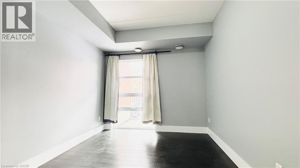 Unfurnished room featuring baseboards and wood finished floors - 155 St. Leger Unit# 107, Kitchener, ON - Indoor Photo Showing Other Room