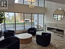 Spacious common area featuring floor-to-ceiling windows, a contemporary electric fireplace with a marble surround, and recessed lighting -