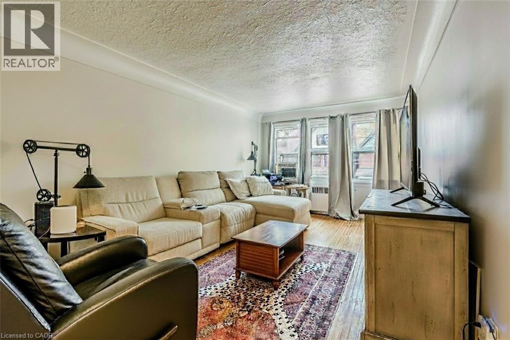 Living room featuring wood finished floors and a textured ceiling - 172 Markland Street, Hamilton, ON - Indoor Photo Showing Living Room