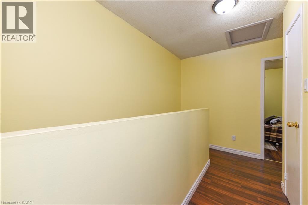 Hallway with attic access, dark wood-type flooring, and a textured ceiling - 85 Enmount Drive, Brampton, ON - Indoor Photo Showing Other Room
