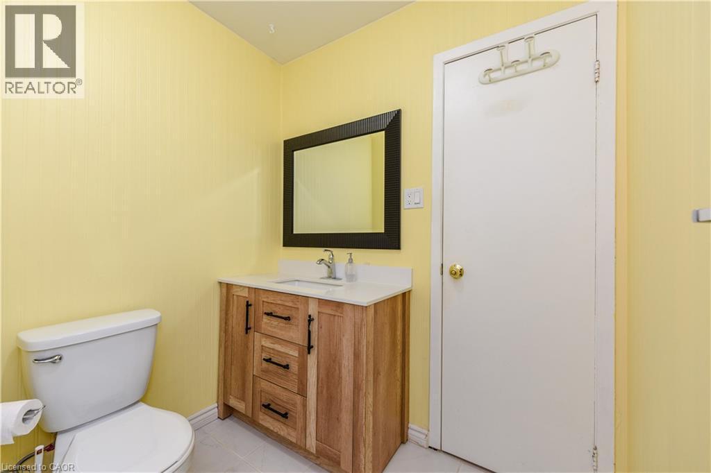 Half bath featuring vanity and light tile patterned floors - 85 Enmount Drive, Brampton, ON - Indoor Photo Showing Bathroom