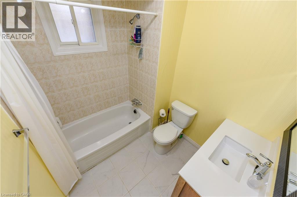 Bathroom with vanity, shower / bath combo with shower curtain, and tile patterned flooring - 85 Enmount Drive, Brampton, ON - Indoor Photo Showing Bathroom