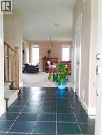 Hall featuring stairs and dark tile patterned floors -