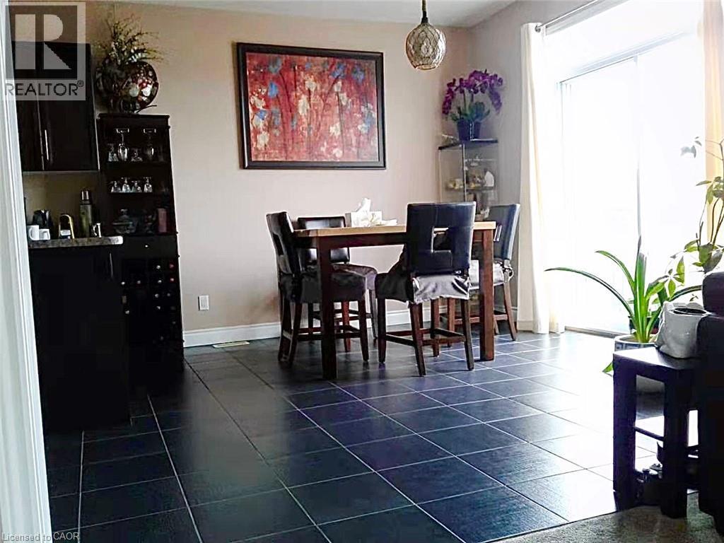 Dining area with dark tile patterned flooring and baseboards - 212 Westfield Place, Waterloo, ON - Indoor Photo Showing Dining Room