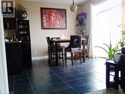 Dining area with dark tile patterned flooring and baseboards -