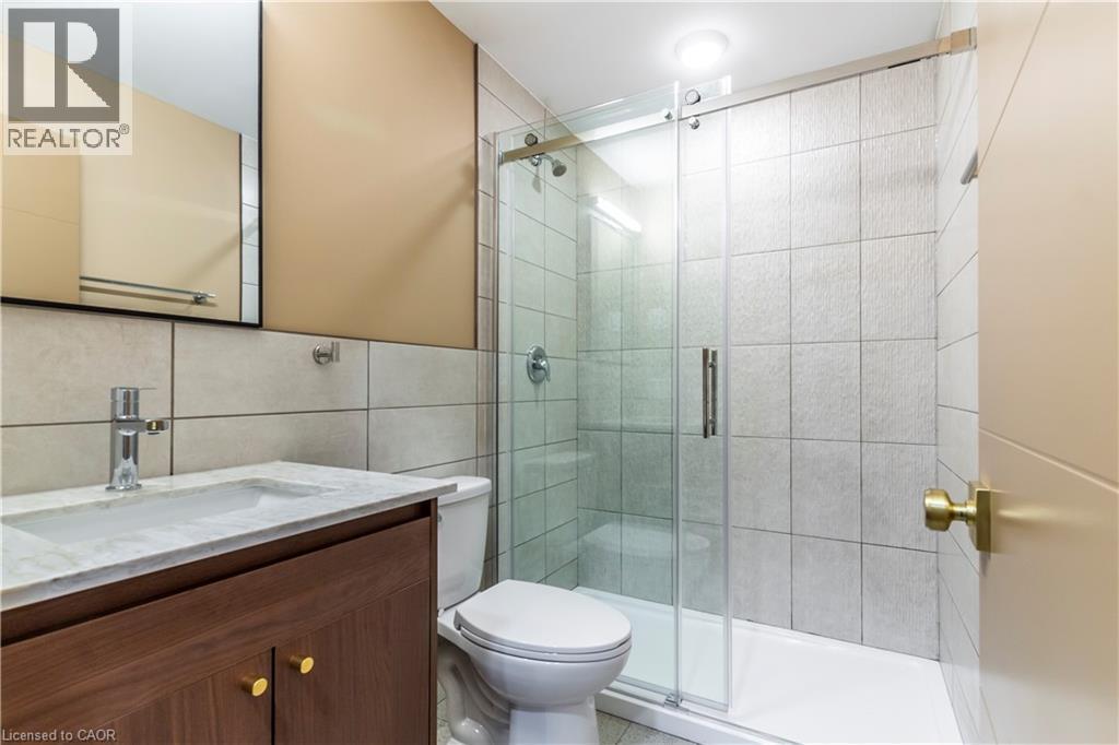 Full bathroom featuring vanity, a stall shower, and tile walls - 580 Coldstream Drive Unit# 212, Waterloo, ON - Indoor Photo Showing Bathroom