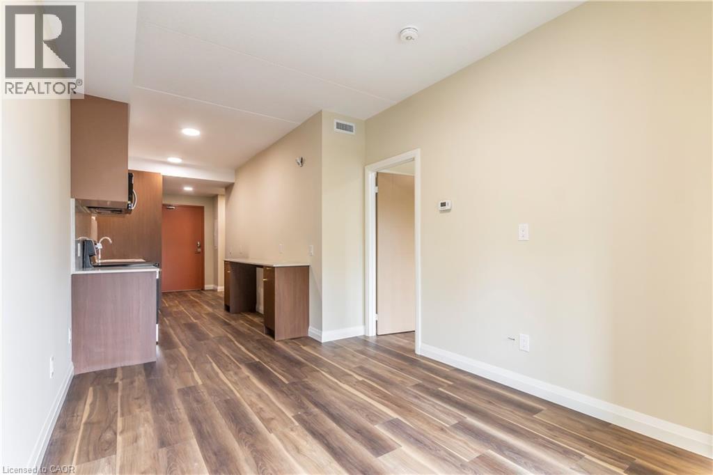 Unfurnished living room with dark wood-style floors and recessed lighting - 580 Coldstream Drive Unit# 212, Waterloo, ON - Indoor Photo Showing Other Room