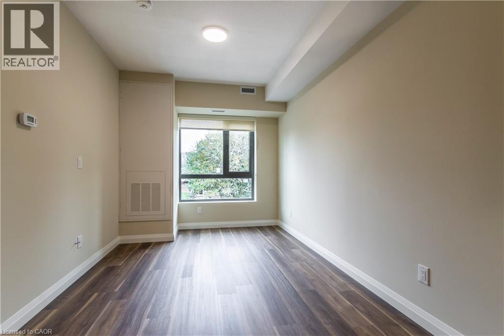 Spare room featuring baseboards and dark wood-type flooring - 580 Coldstream Drive Unit# 212, Waterloo, ON - Indoor Photo Showing Other Room