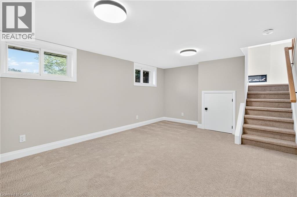 Below grade area with light colored carpet and stairway - 4006 Flemish Drive, Burlington, ON - Indoor Photo Showing Other Room