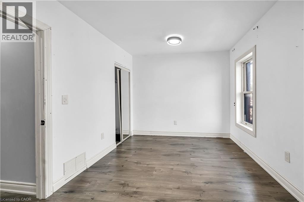Unfurnished room with dark wood-type flooring and baseboards - 334 Cannon Street E, Hamilton, ON - Indoor Photo Showing Other Room