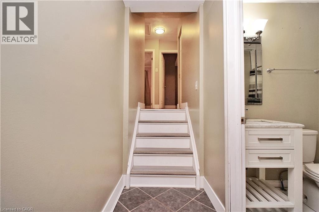 Stairs featuring tile patterned flooring and baseboards - 61 Bosworth Crescent, Kitchener, ON - Indoor Photo Showing Other Room