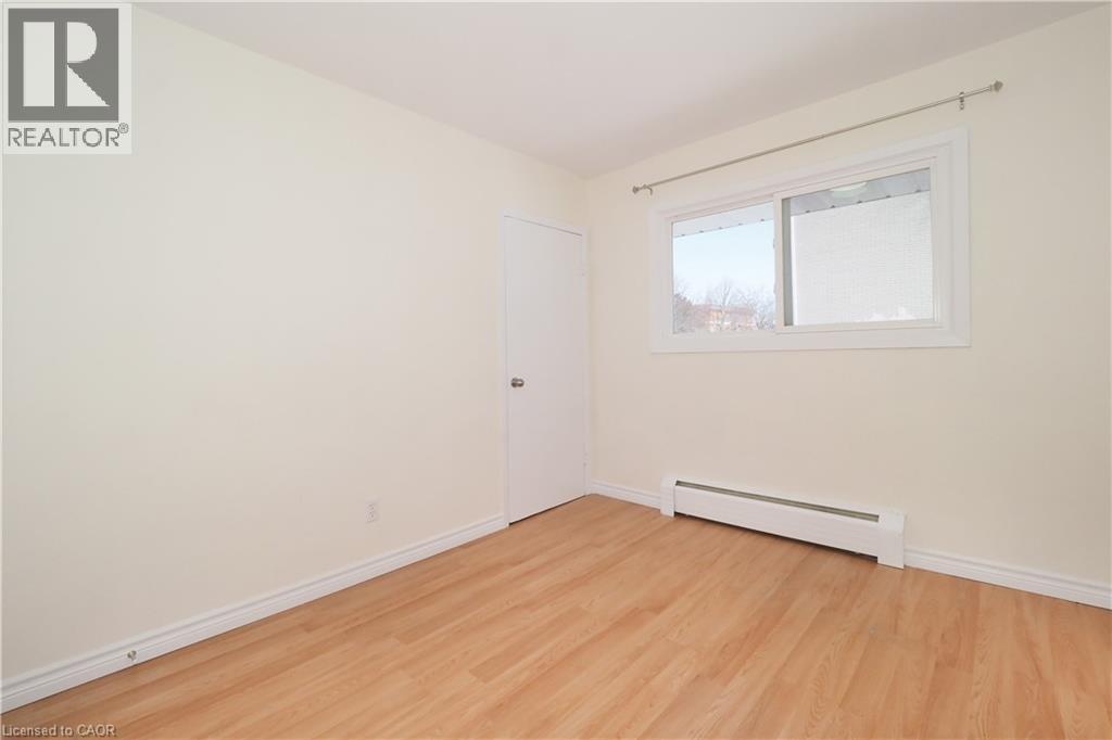 Empty room featuring a baseboard radiator and light wood finished floors - 24 Austin Drive, Waterloo, ON - Indoor Photo Showing Other Room