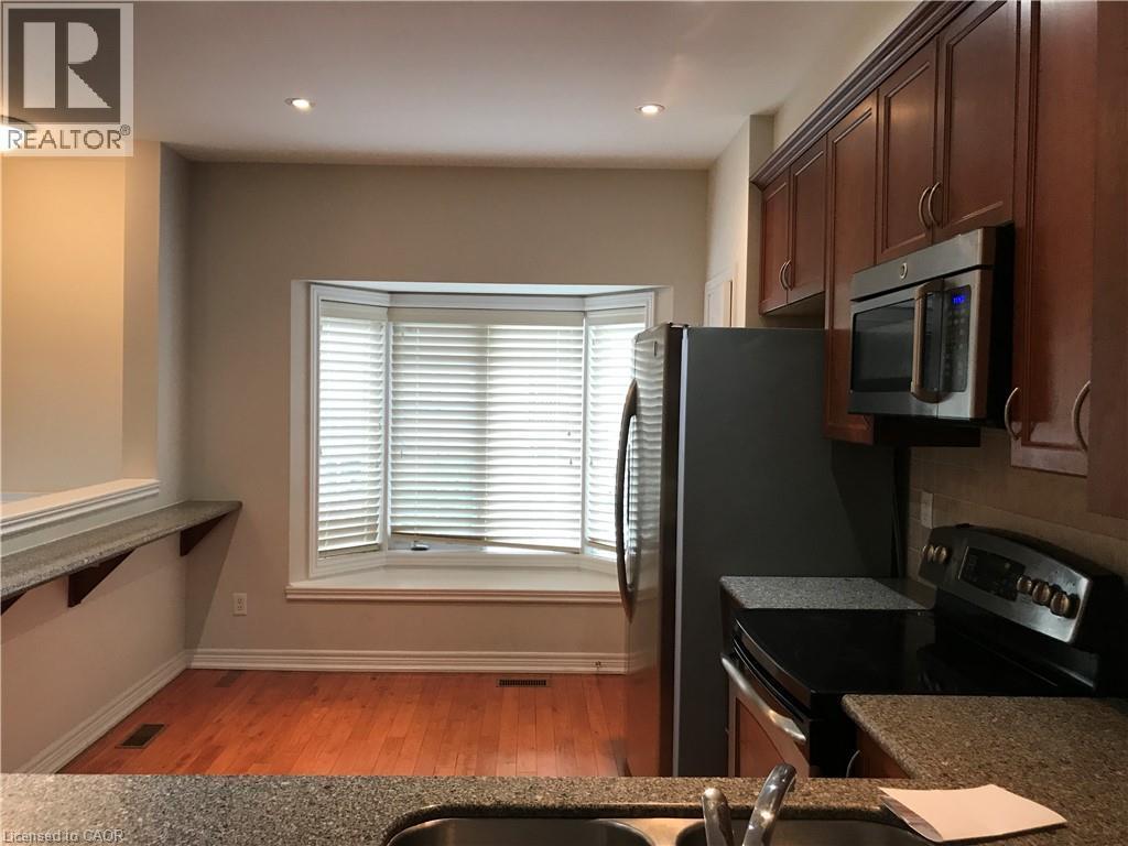 Kitchen featuring appliances with stainless steel finishes, light wood-style floors, recessed lighting, and tasteful backsplash - 4294 Ingram Common, Burlington, ON - Indoor Photo Showing Kitchen