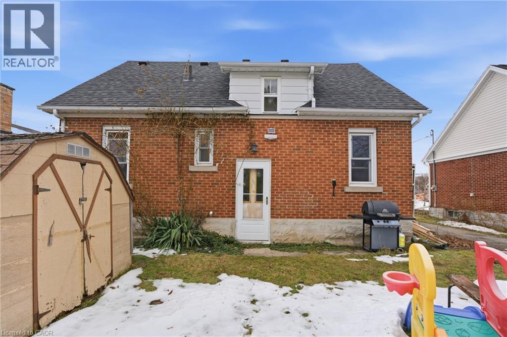 Rear view of house with a storage shed, brick siding, a patio, and roof with shingles - 157 Bridgeport Road E, Waterloo, ON - Outdoor With Exterior