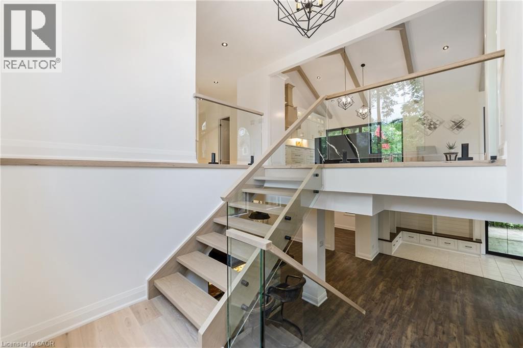Oak staircase with open risers and glass rail leading to finished basement - 515 Hamilton Drive, Ancaster, ON - Indoor Photo Showing Other Room