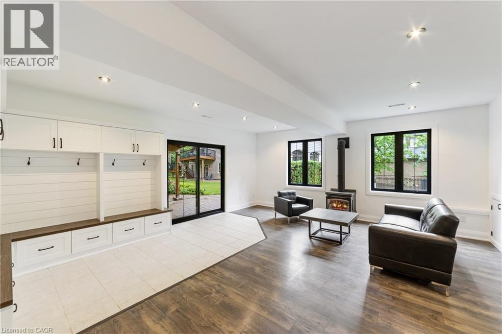 Basement custom white cabinetry for added storage, gas stove, recessed lighting, laminate flooring, multiple at grade windows, sliding back door backs onto lower patio - 515 Hamilton Drive, Ancaster, ON - Indoor