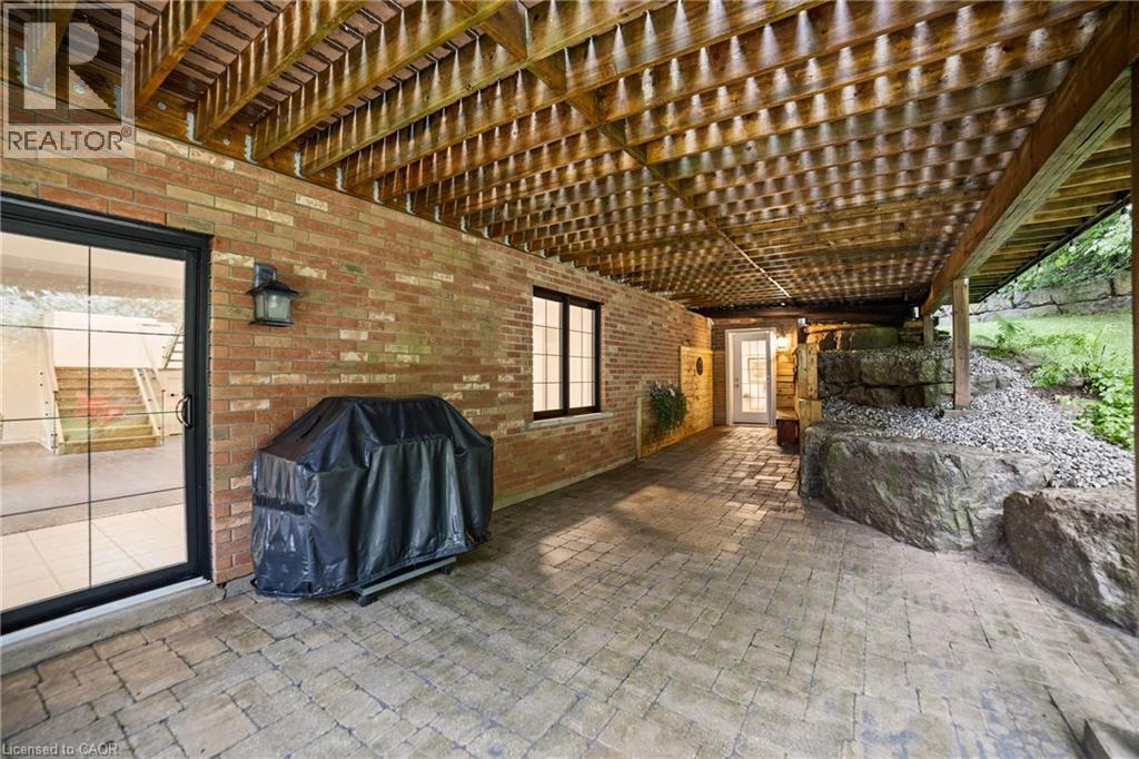 Walk-out from basement to large interlocking brick patio with panoramic view of the property, separate exterior entrance at the back of photo leads to the in-law suite - 515 Hamilton Drive, Ancaster, ON - Outdoor With Exterior
