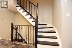 Stairs with wood finished floors and baseboards -