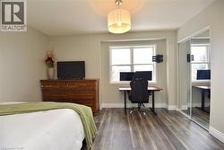 Bedroom with wood finished floors, a closet, and an office area -