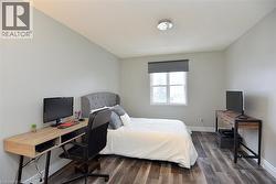 Bedroom with wood finished floors, a desk, and a textured ceiling -