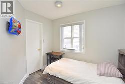 Bedroom featuring dark wood finished floors and baseboards -