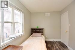Bedroom featuring baseboards and dark wood-style flooring -