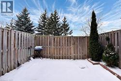 Snowy yard with a fenced backyard -