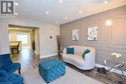 Sitting room with wood finished floors, a decorative wall, a textured ceiling, and recessed lighting -