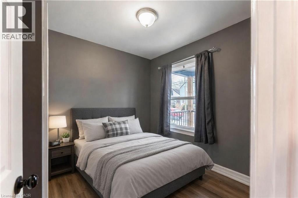 Bedroom with dark wood-style flooring and baseboards - 140 Royal Avenue, Hamilton, ON - Indoor Photo Showing Bedroom