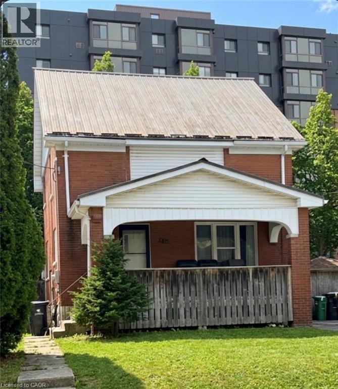 Contemporary home featuring a front lawn, brick siding, covered porch, and a metal roof - 179 Regina Street N, Waterloo, ON - Outdoor