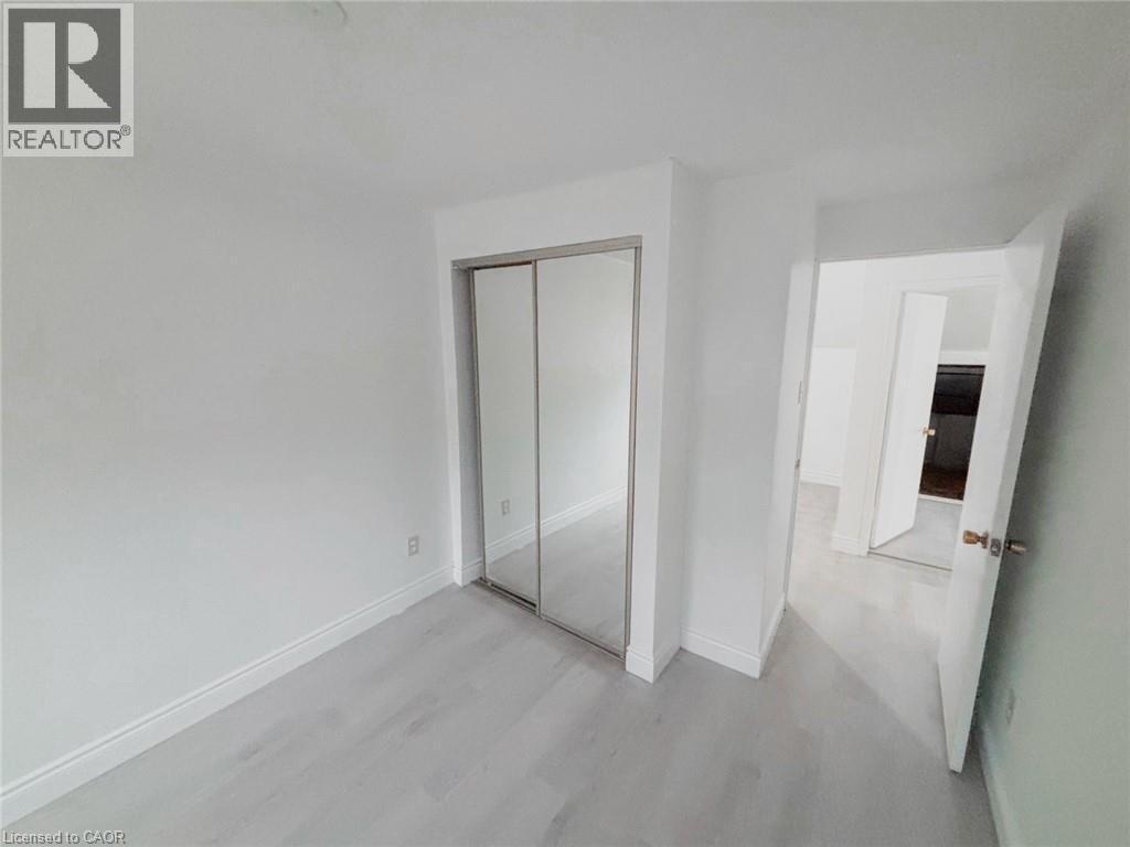 Unfurnished bedroom with a closet and light wood-style flooring - 1949 Old Mill Road, Kitchener, ON - Indoor Photo Showing Other Room