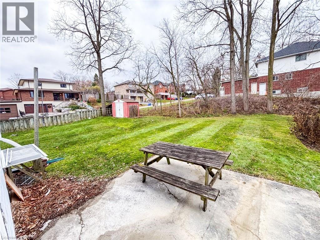 Fenced backyard featuring a residential view, a shed, and a patio area - 1949 Old Mill Road, Kitchener, ON - Outdoor