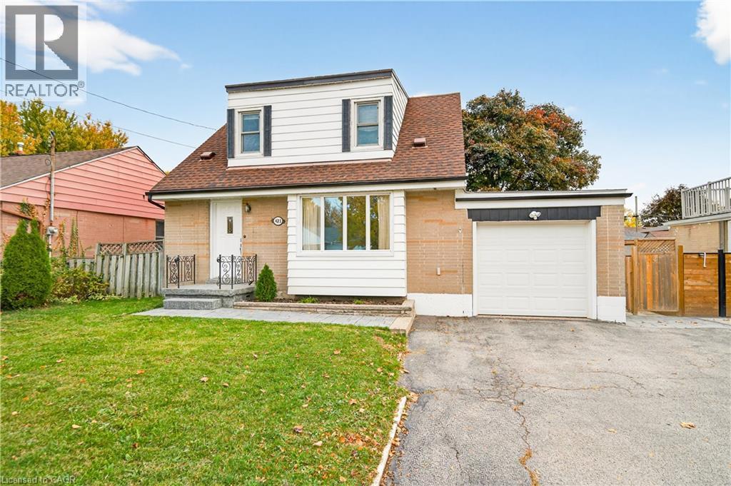 View of front of property featuring a shingled roof, brick siding, asphalt driveway, and an attached garage - 421 East 36Th Street, Hamilton, ON - Outdoor