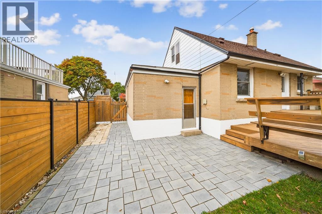 Back of house with a patio area, a gate, a chimney, and brick siding - 421 East 36Th Street, Hamilton, ON - Outdoor With Exterior