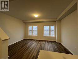 Empty room featuring baseboards and dark wood finished floors -