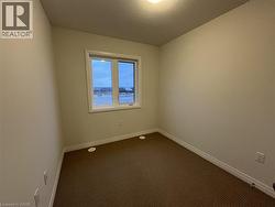 Carpeted spare room with baseboards -