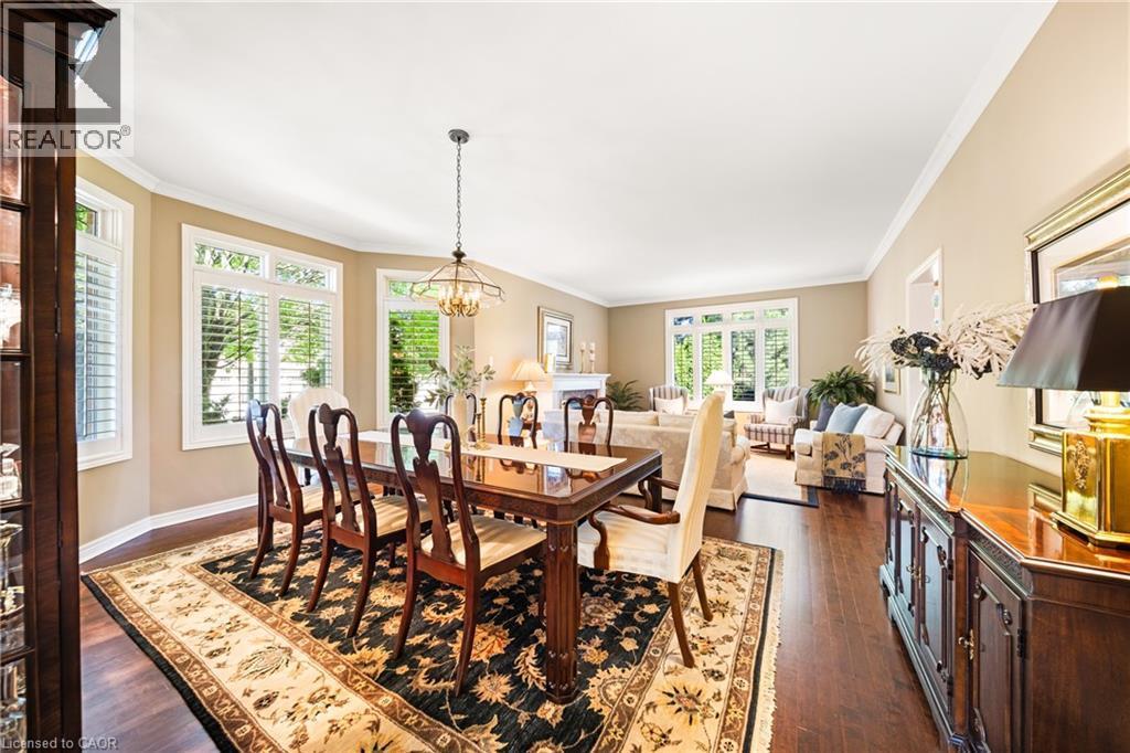 Dining room featuring ornamental molding, dark wood-style flooring, and a chandelier - 4165 Stonebridge Crescent, Burlington, ON - Indoor Photo Showing Dining Room
