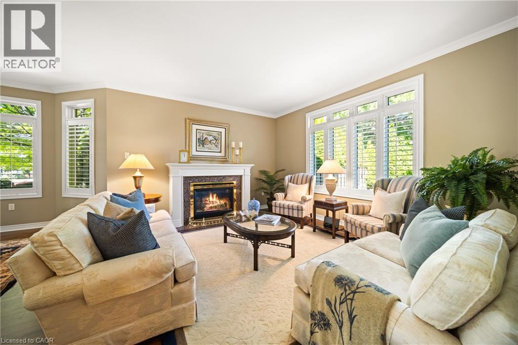 Living area with crown molding, a fireplace, and healthy amount of natural light - 4165 Stonebridge Crescent, Burlington, ON - Indoor Photo Showing Living Room With Fireplace
