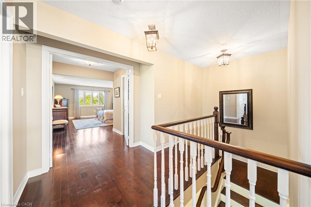 Hallway featuring an upstairs landing, dark wood finished floors, and a textured ceiling - 4165 Stonebridge Crescent, Burlington, ON - Indoor Photo Showing Other Room