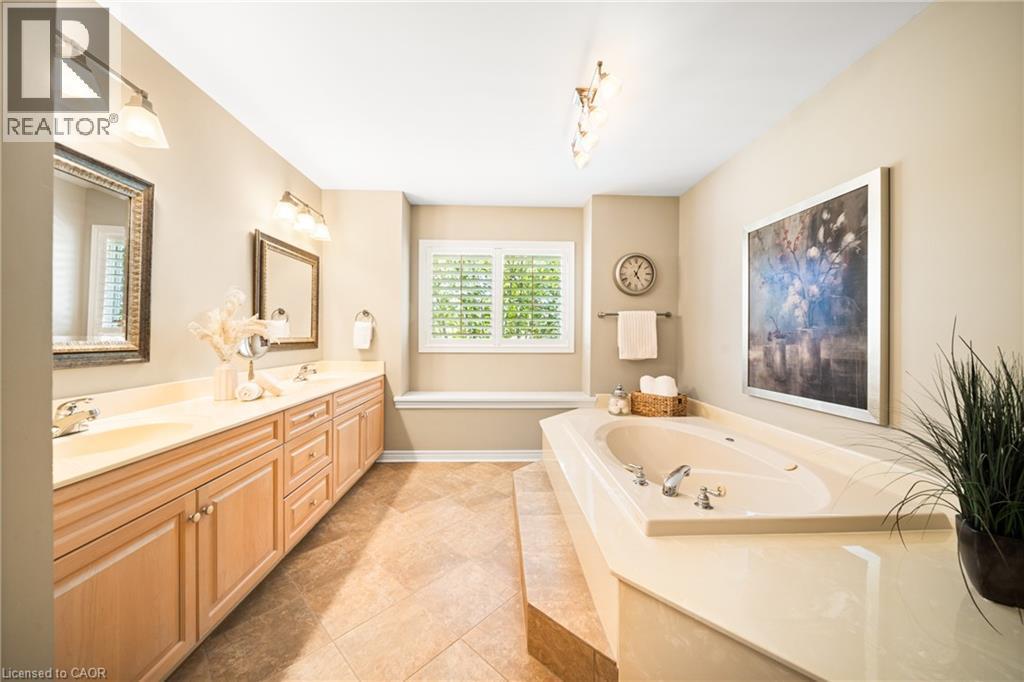 Bathroom with double vanity, a bath, and light tile patterned flooring - 4165 Stonebridge Crescent, Burlington, ON - Indoor Photo Showing Bathroom