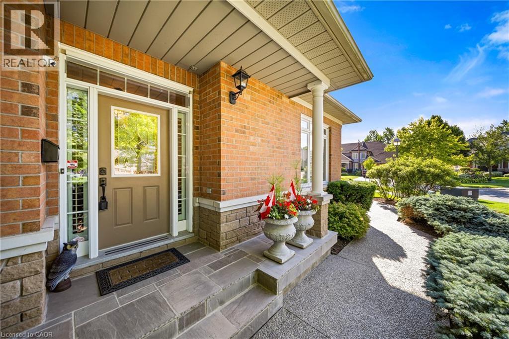 View of exterior entry with covered porch and brick siding - 4165 Stonebridge Crescent, Burlington, ON - Outdoor With Deck Patio Veranda With Exterior