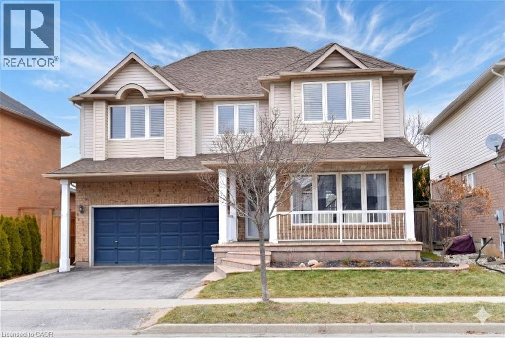 Traditional home featuring covered porch, an attached garage, asphalt driveway, and a shingled roof - 5109 Blue Spruce Avenue, Burlington, ON - Outdoor With Deck Patio Veranda With Facade