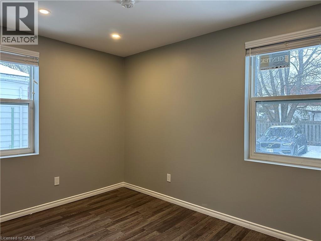 Empty room with dark wood-style floors and recessed lighting - 80 Glen Road Unit# Upper, Kitchener, ON - Indoor Photo Showing Other Room