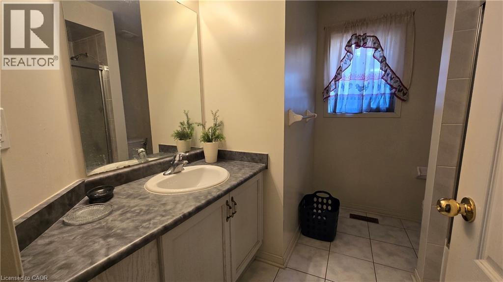 Full bathroom featuring vanity, light tile patterned floors, and a shower with door - 3688 Emery Drive, Mississauga, ON - Indoor Photo Showing Bathroom