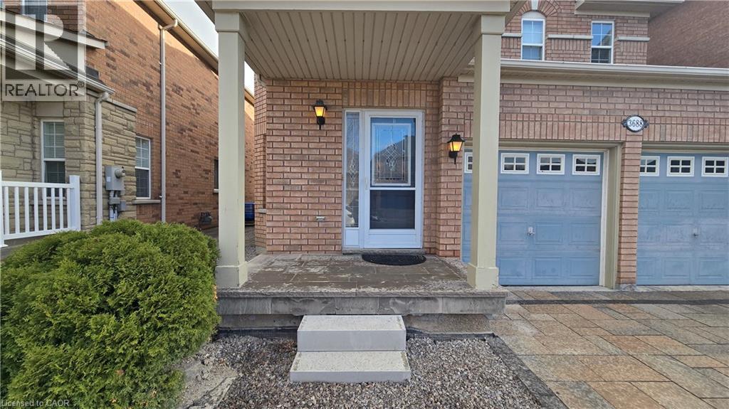 Property entrance with brick siding, an attached garage, covered porch, and driveway - 3688 Emery Drive, Mississauga, ON - Outdoor