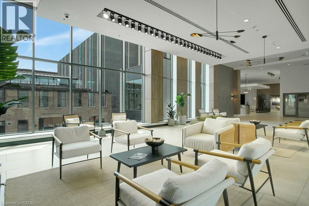 Community lobby featuring a towering ceiling, a wall of windows, and a surveillance system - 15 Glebe Street Unit# 1511, Cambridge, ON - Indoor Photo Showing Other Room