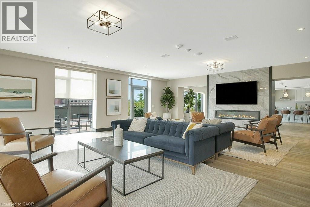 Living room with light wood-style flooring, plenty of natural light, a high end fireplace, and recessed lighting - 15 Glebe Street Unit# 1511, Cambridge, ON - Indoor Photo Showing Living Room With Fireplace